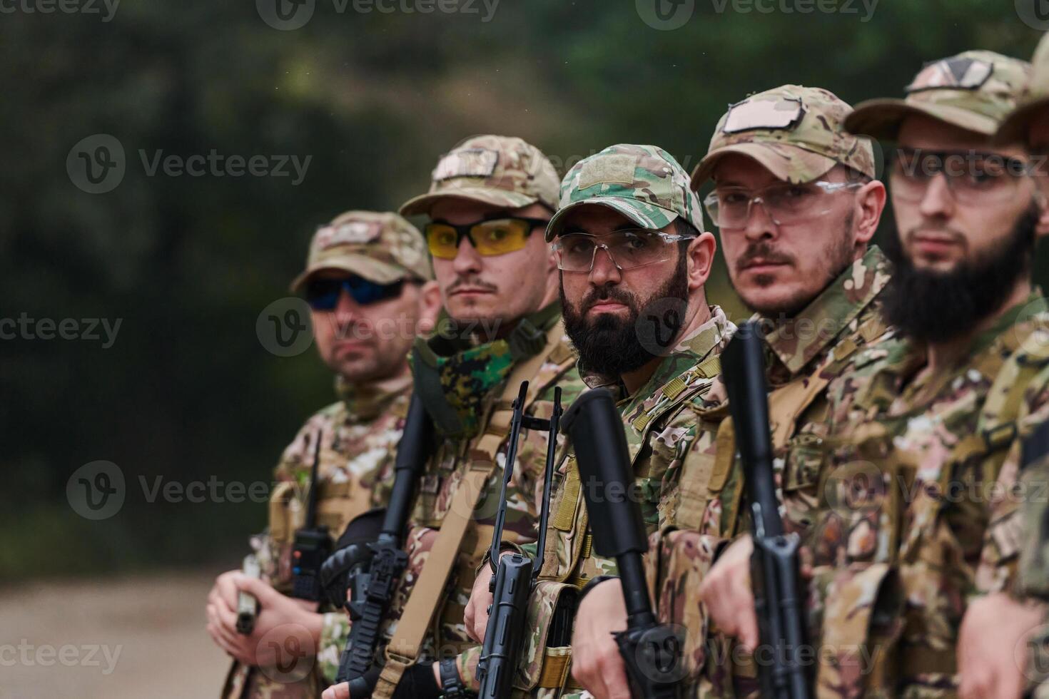 Soldier fighters standing together with guns. Group portrait of US army elite members, private military company servicemen, anti terrorist squad photo