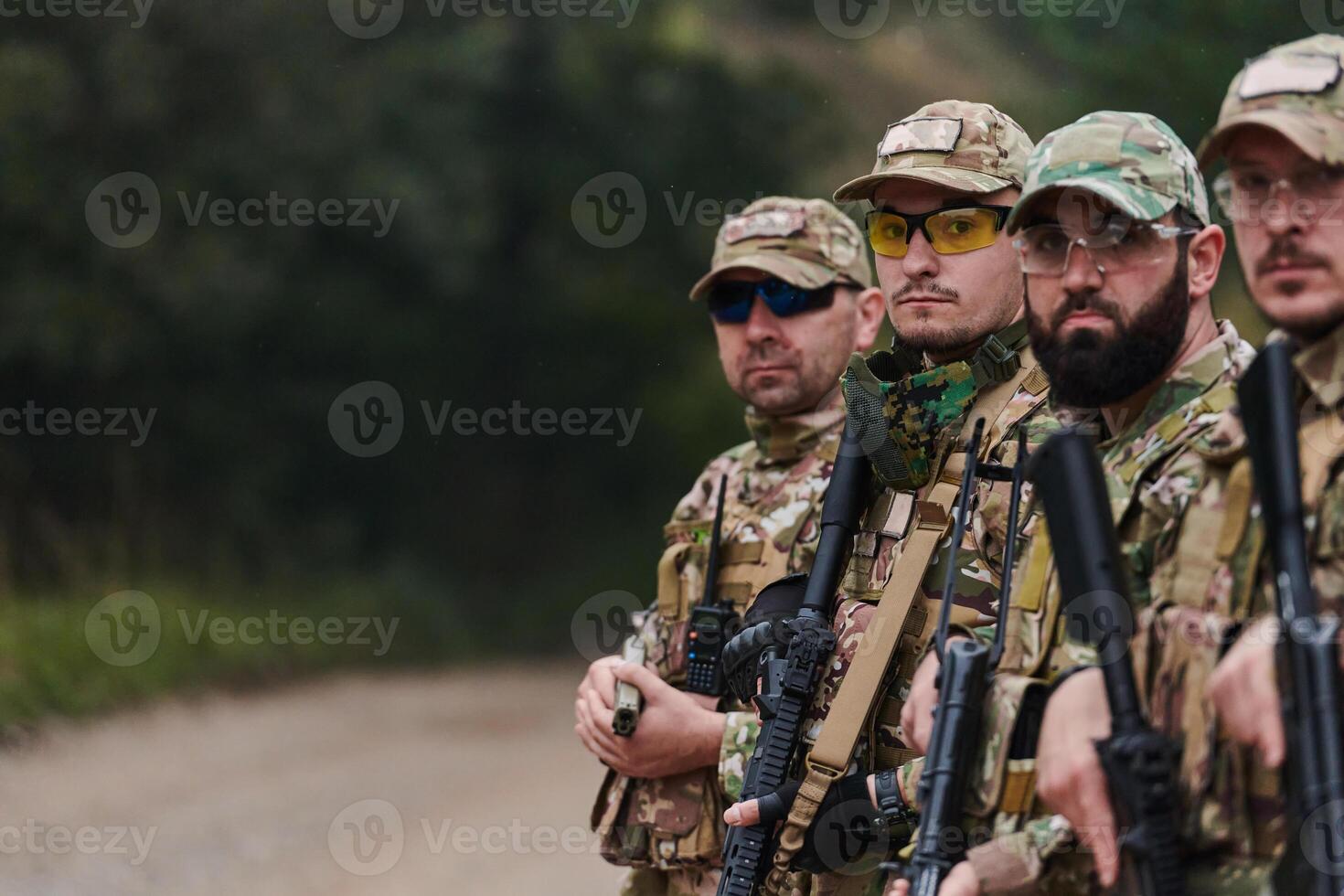 Soldier fighters standing together with guns. Group portrait of US army elite members, private military company servicemen, anti terrorist squad photo