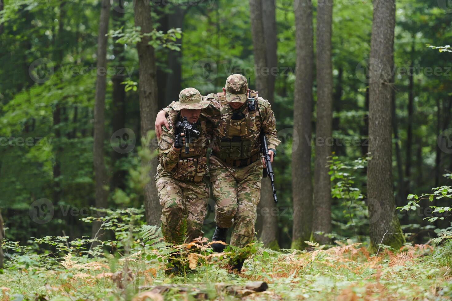 Elite soldier displays unwavering camaraderie and compassion as he aids his injured comrade, skillfully extracting him from the forest with a stretcher, showcasing the profound bond and selflessness photo