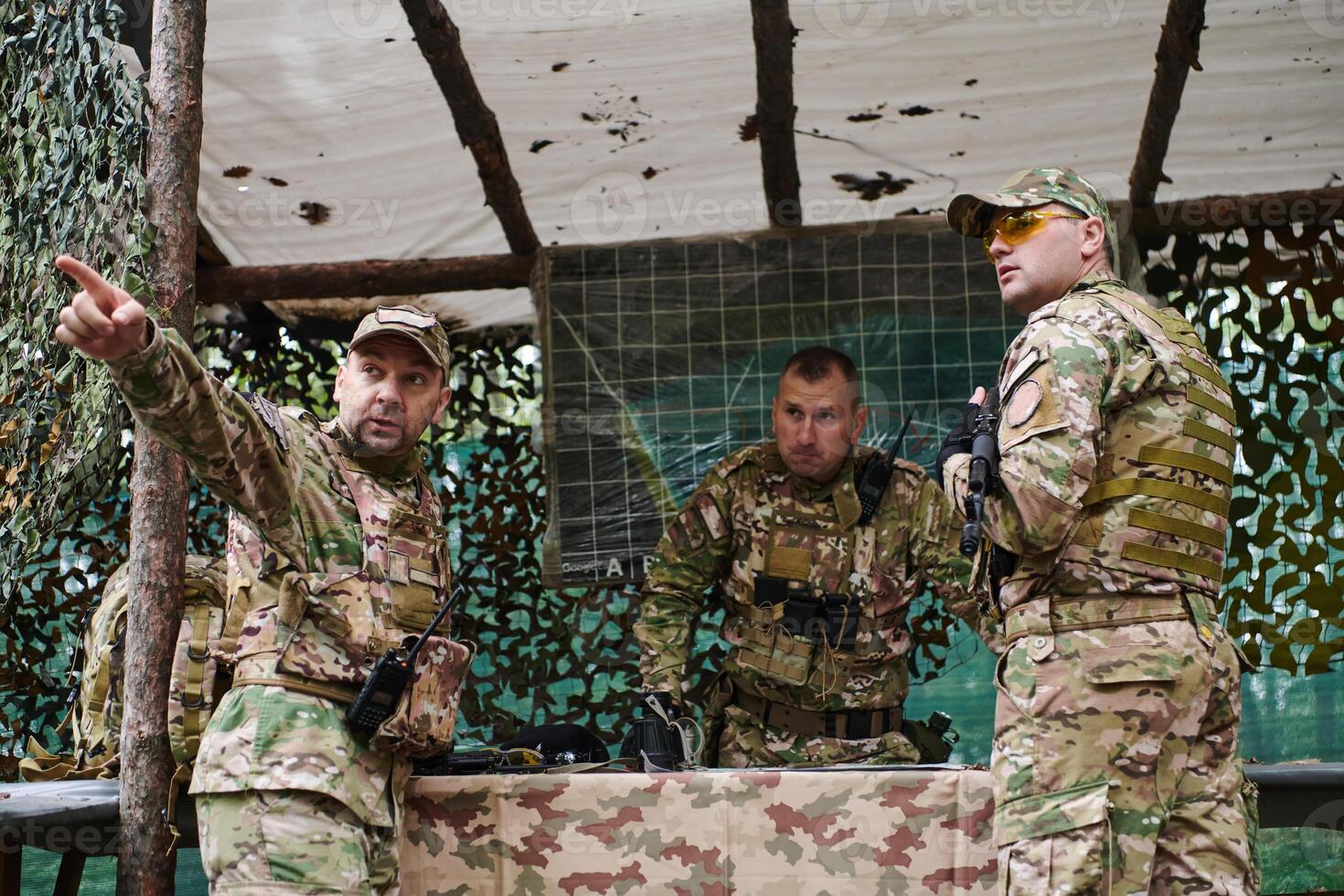 A highly trained military unit strategizes and organizes a tactical mission while studying a military map during a briefing session photo