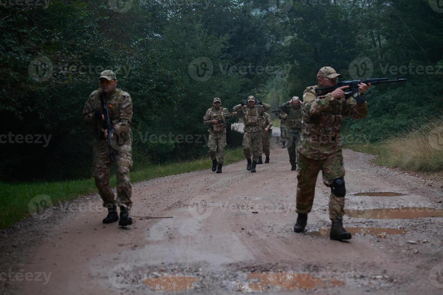 A group of elite soldiers leads captives through a military camp, showcasing a tense atmosphere of detention and security operations photo