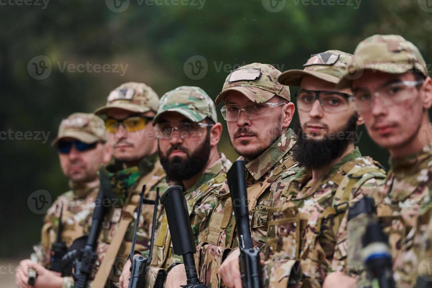 Soldier fighters standing together with guns. Group portrait of US army elite members, private military company servicemen, anti terrorist squad photo