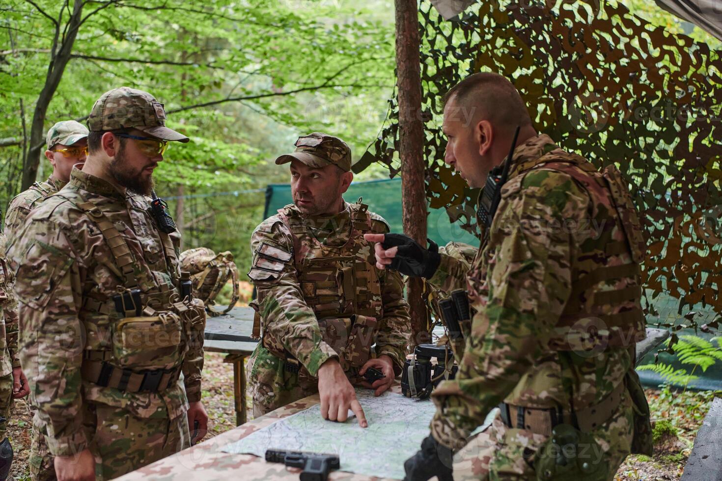 A highly trained military unit strategizes and organizes a tactical mission while studying a military map during a briefing session photo