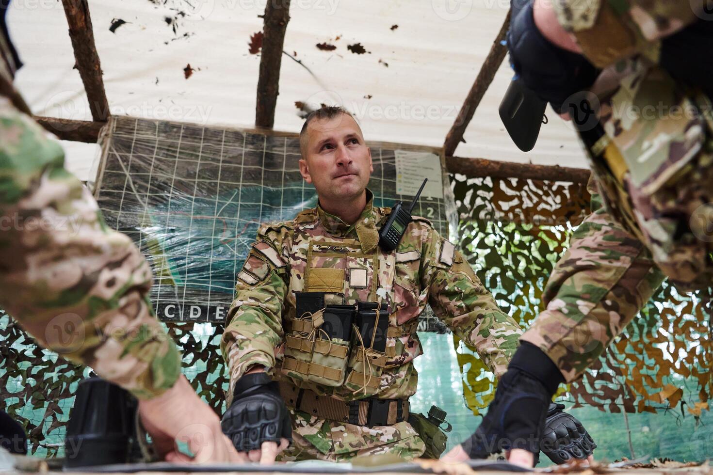 A highly trained military unit strategizes and organizes a tactical mission while studying a military map during a briefing session photo