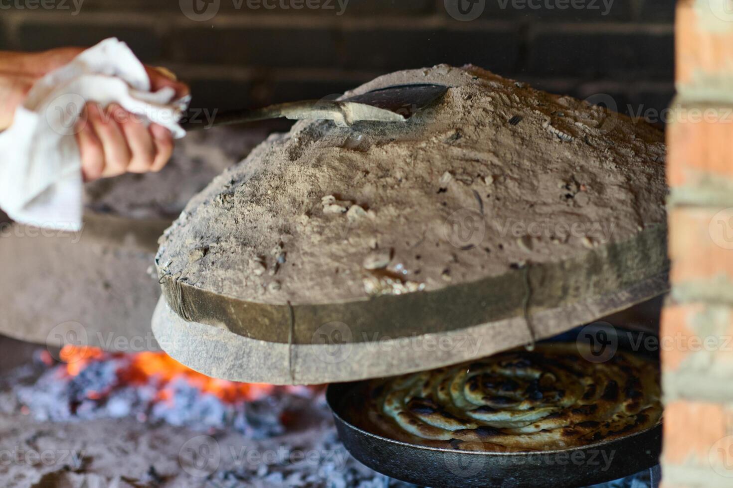Capturing the essence of Bosnian culinary tradition, step-by-step preparation of a traditional Bosnian pie, showcasing the meticulous craftsmanship and authentic flavors involved in the culinary photo