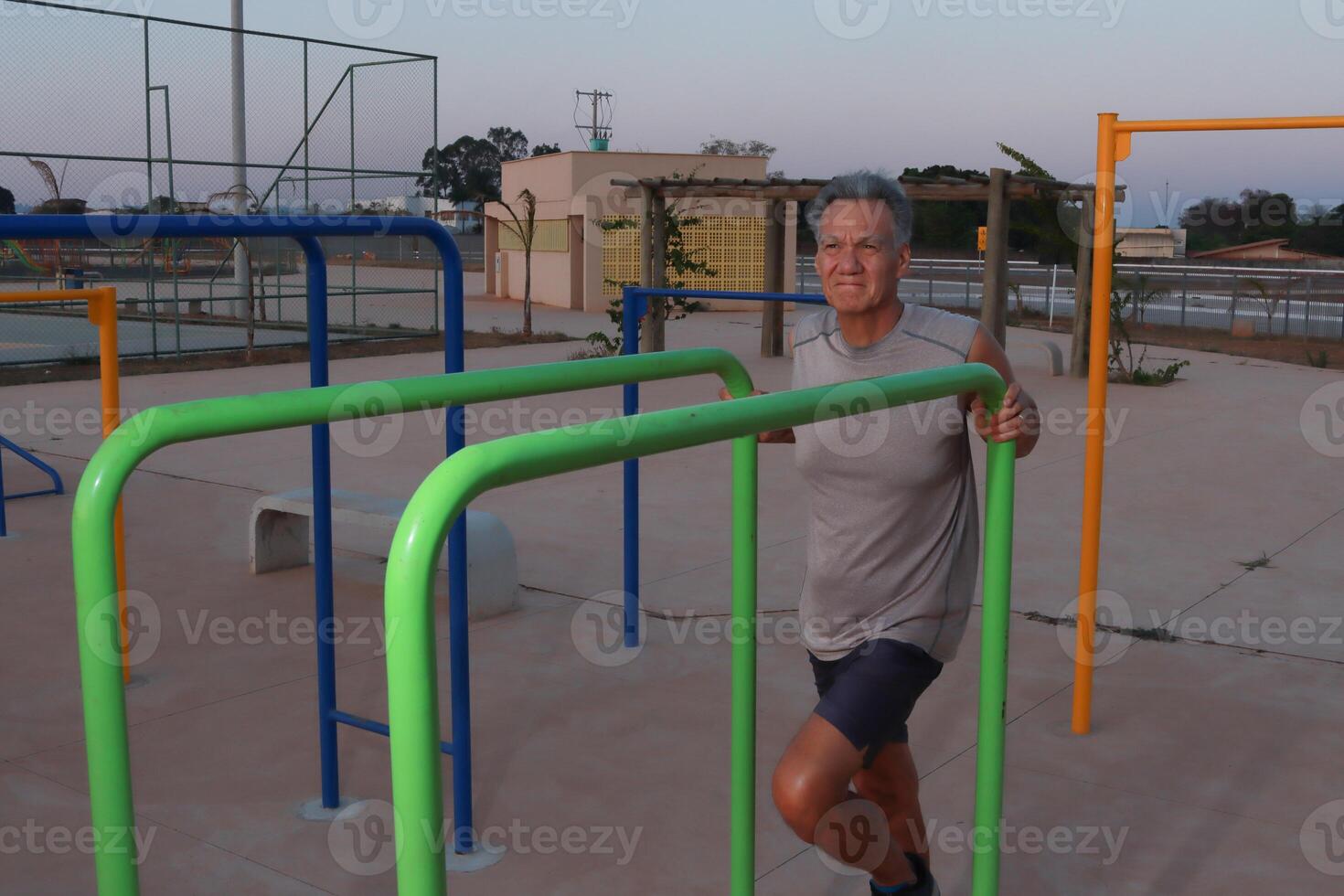 Older Mature Man relaxing at an outdoor fitness park after working out photo