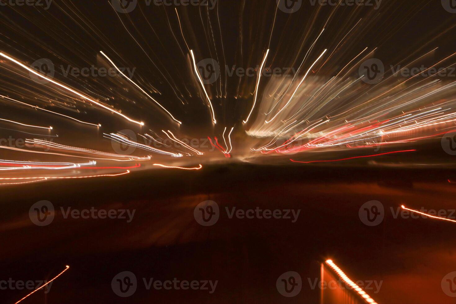 Abstract Light trails at night leaving bright squiggly lines of white and red trails photo