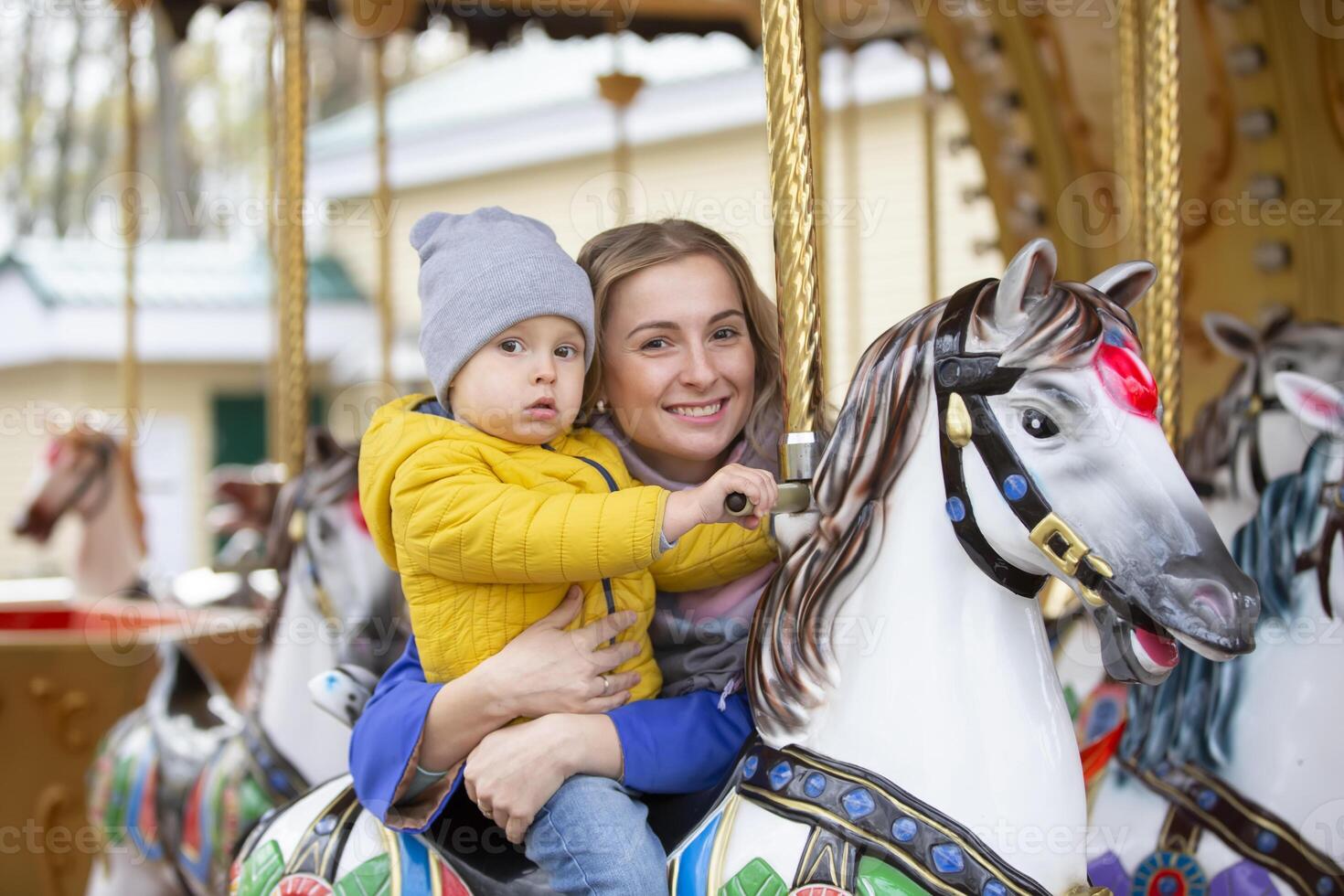 Mom with a cheerful baby on a carousel.Mother's love. photo
