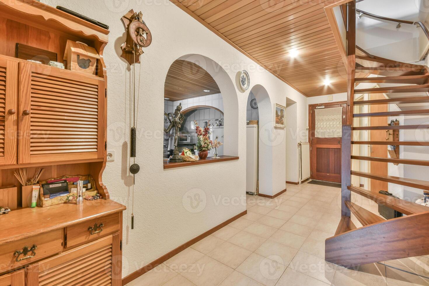 A hallway with wooden cabinets and a staircase photo