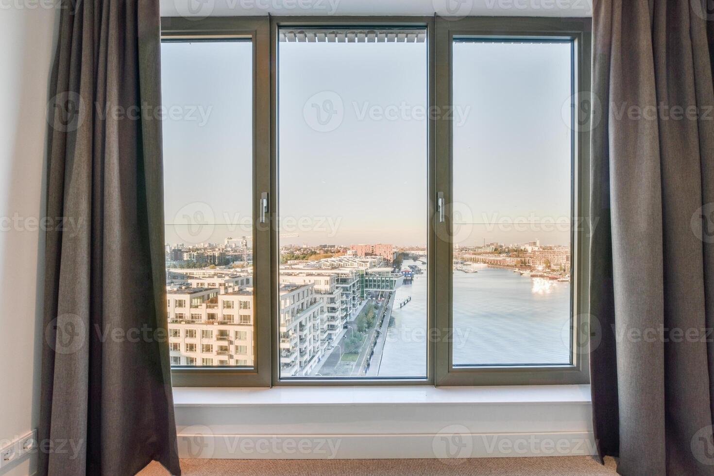 A window with curtains and a view of a river photo