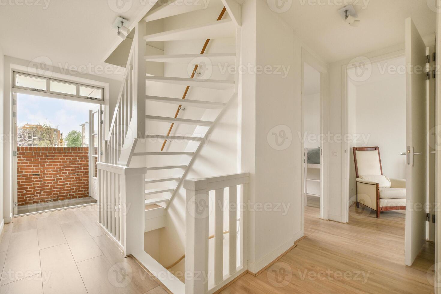 A white staircase in a small room with a window photo