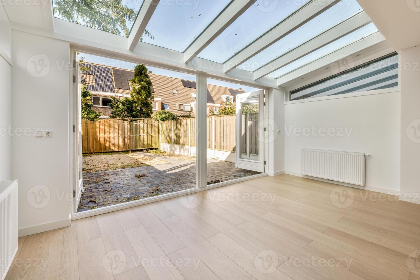 A white room with a skylight and wooden floor photo