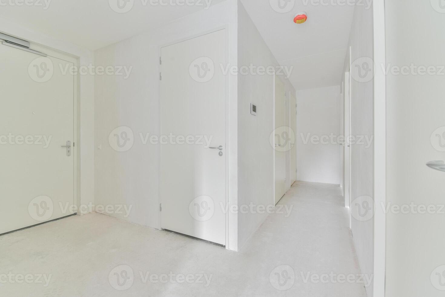 A white hallway with two doors and a white floor photo