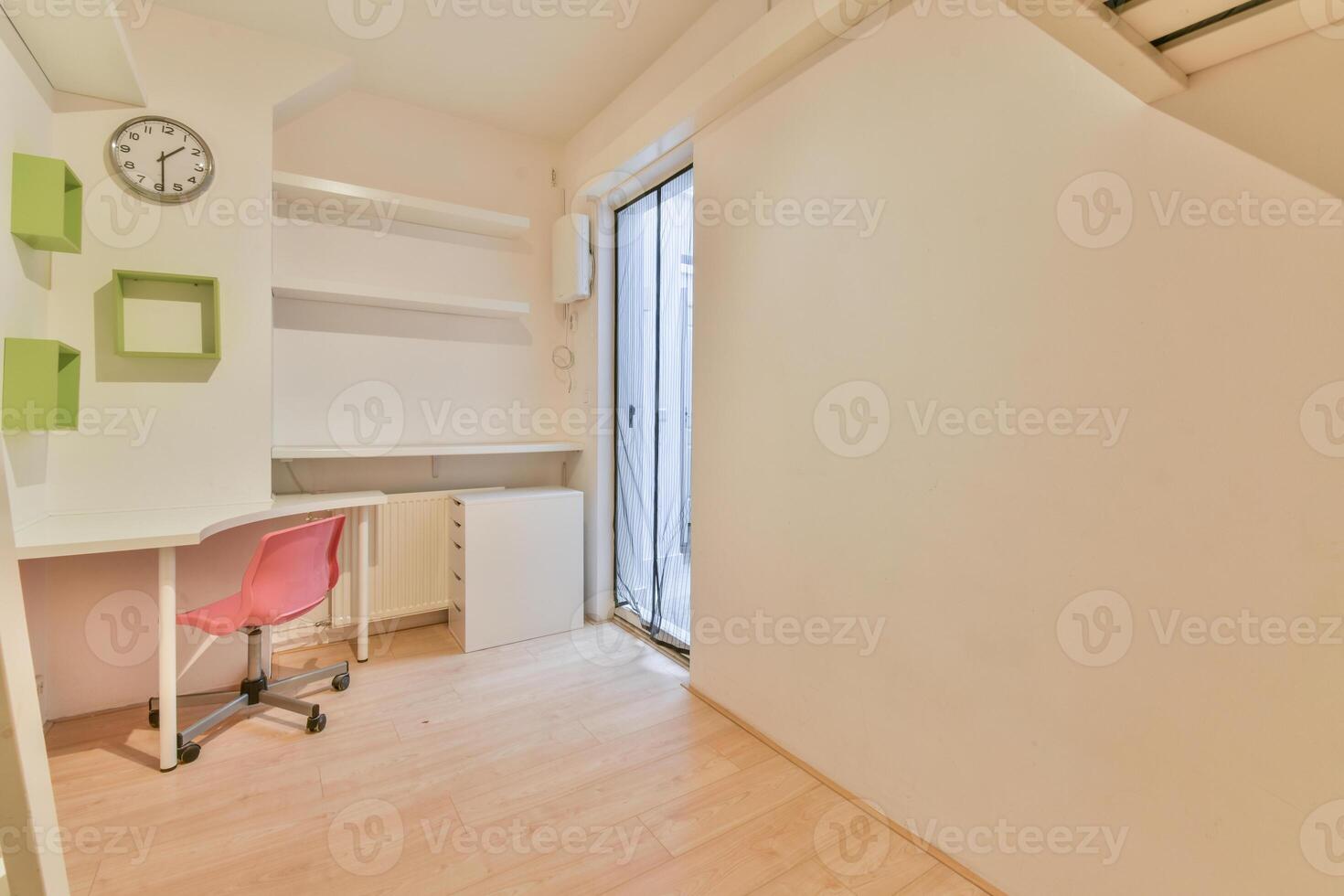 A small room with a desk and chair photo