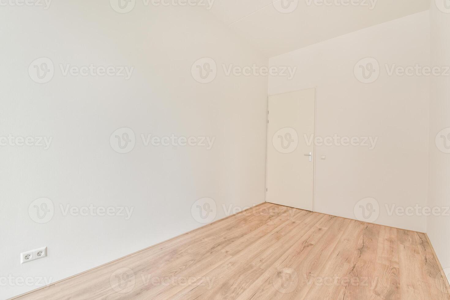 An empty room with wooden floors and white walls photo