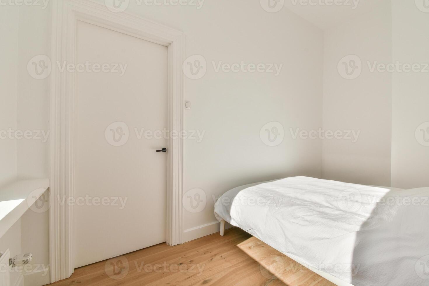 A bedroom with a white bed and wooden floor photo