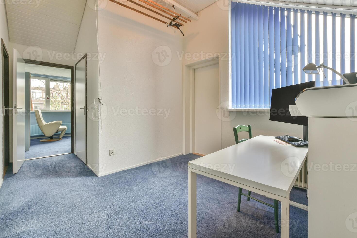 A room with a desk and a window photo