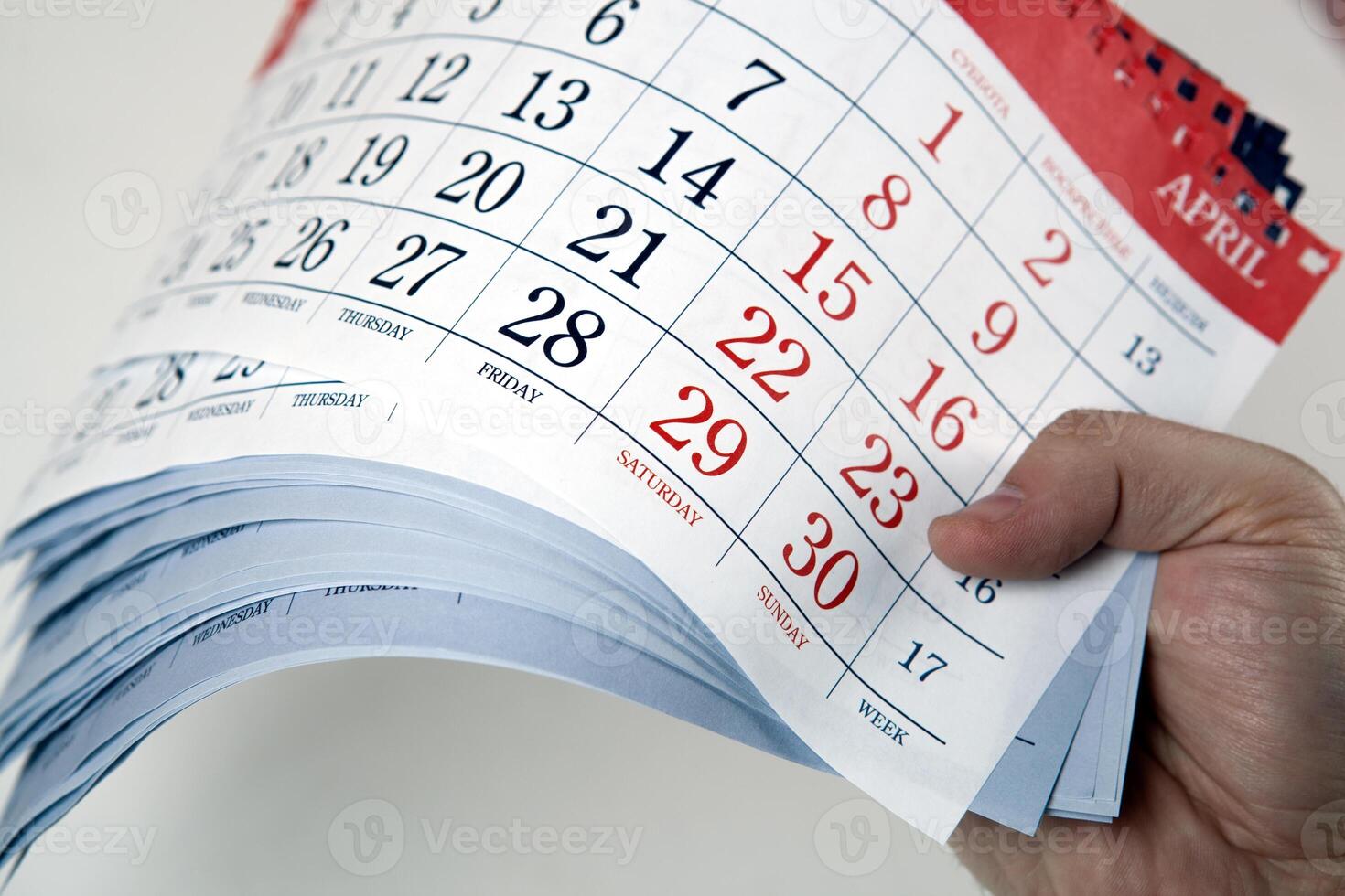 hands of men hold the sheets of the calendar photo