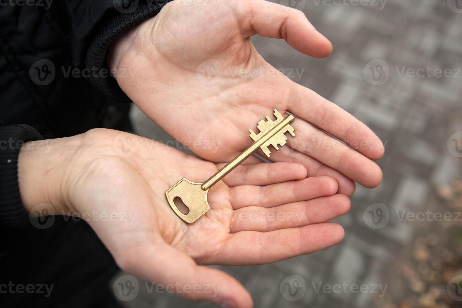 hand holds the key to an apartment in a new building photo