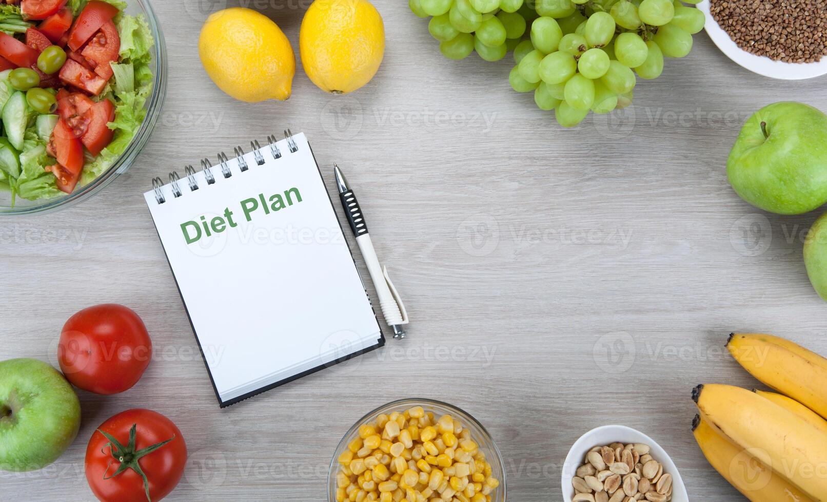 notebook with a diet plan with fresh vegetables and fruits on the table photo
