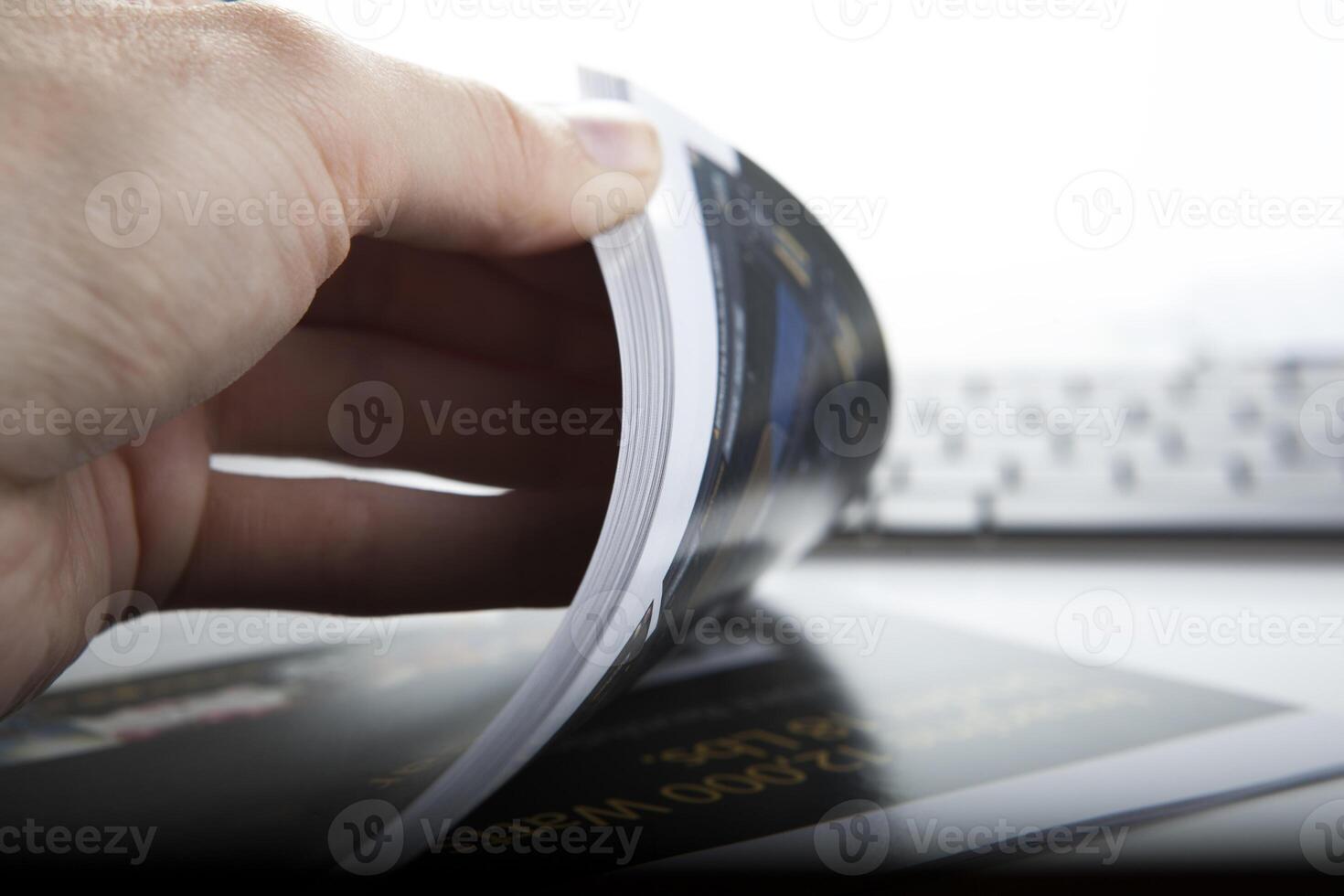 the hand through the pages of the magazine photo