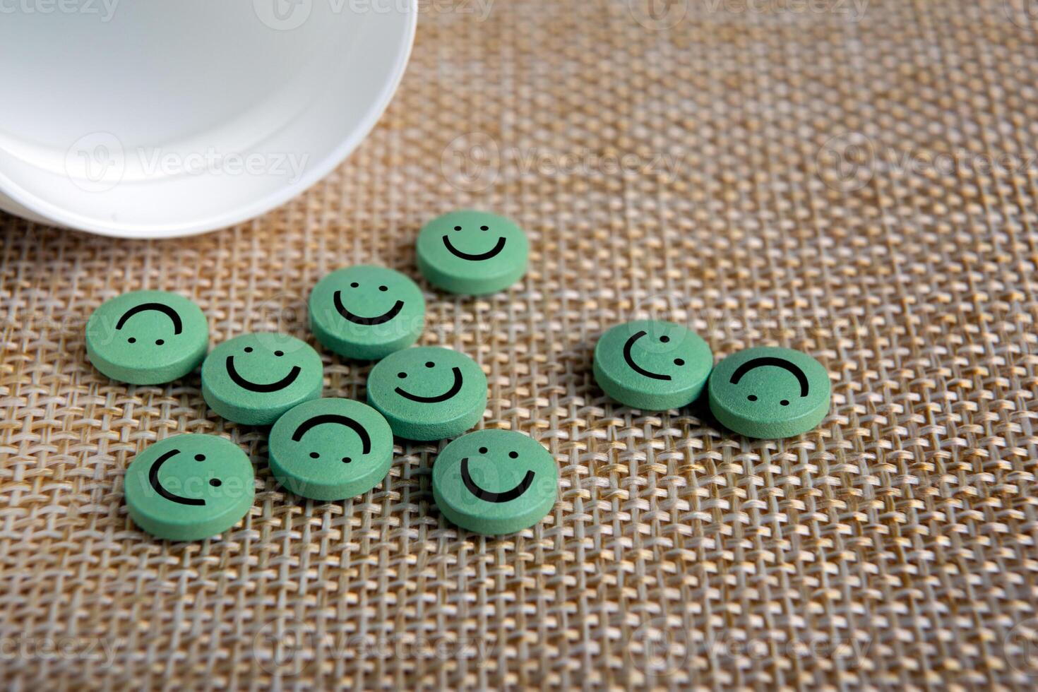 green round pills of antidepressant with emoticons poured photo