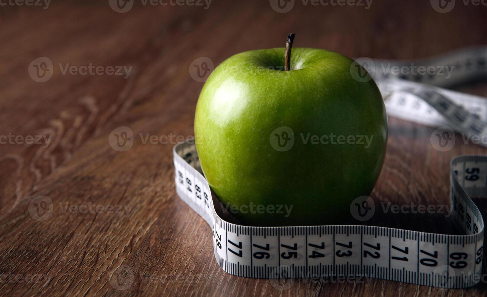 fresh green apple on a wooden table with measure photo