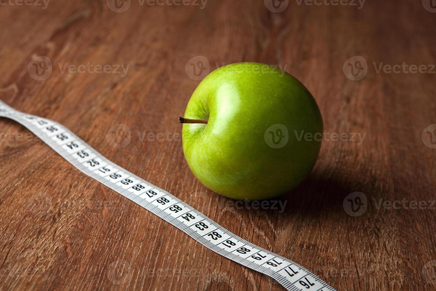 fresh green apple on a wooden table with measure photo