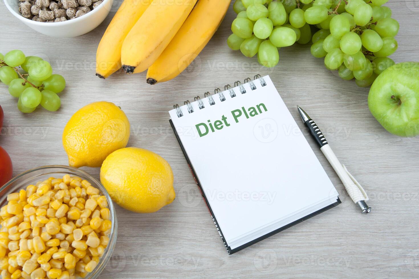 notebook with a diet plan with fresh vegetables and fruits on the table photo