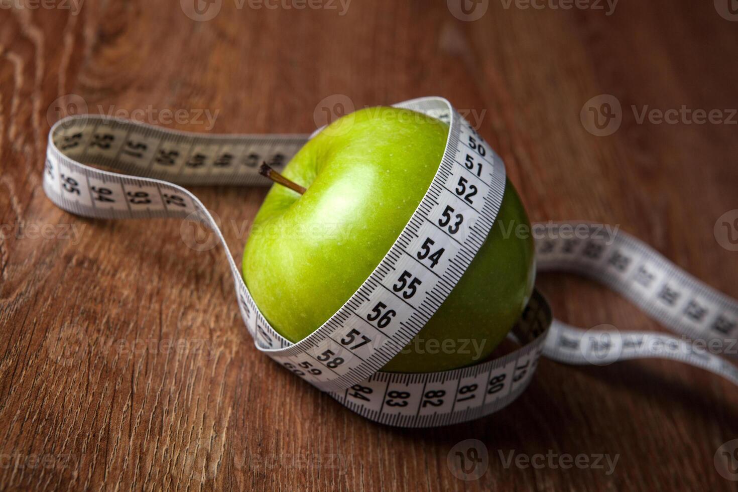 fresh green apple on a wooden table with measure photo