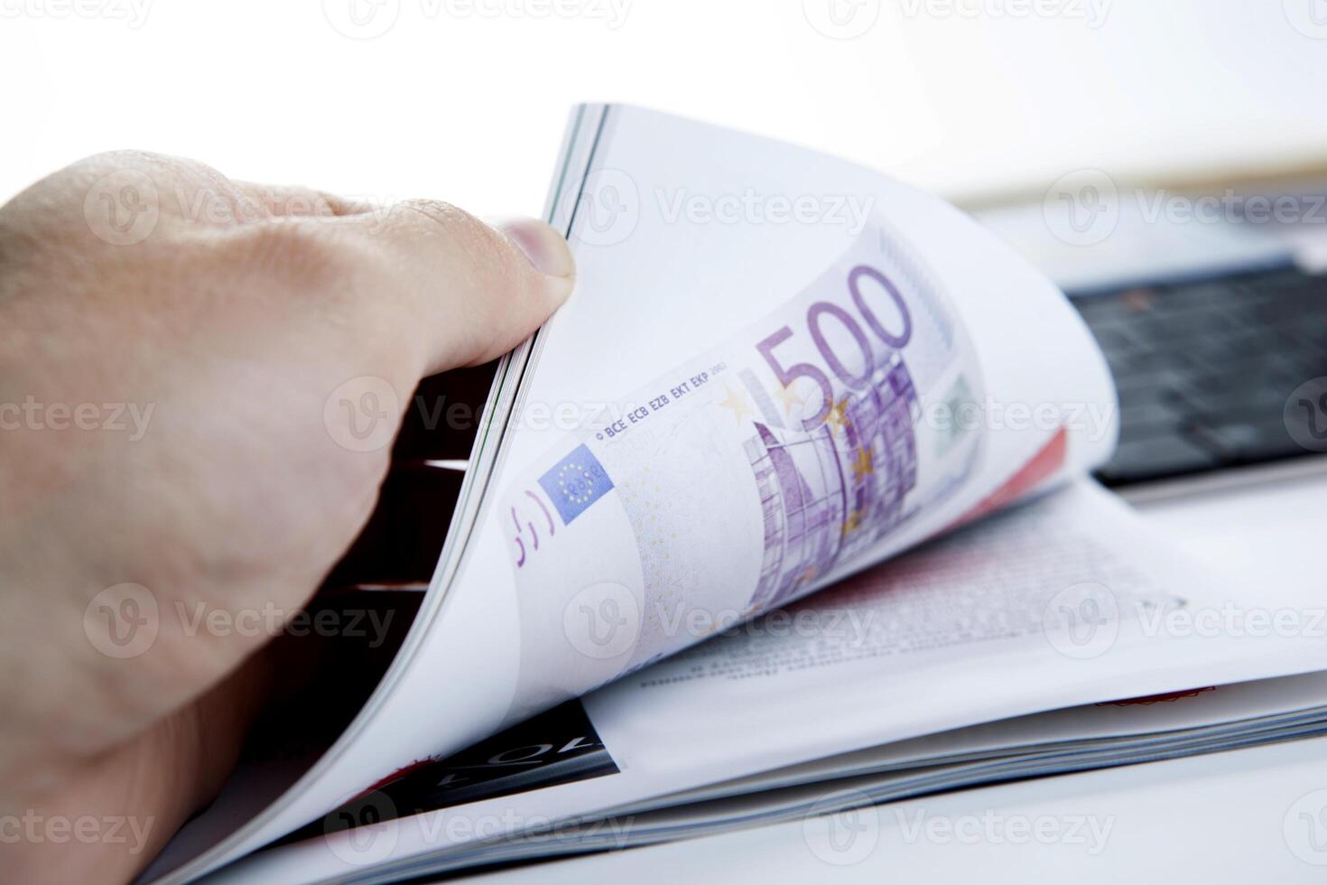 the hand through the pages of the magazine with currency note photo