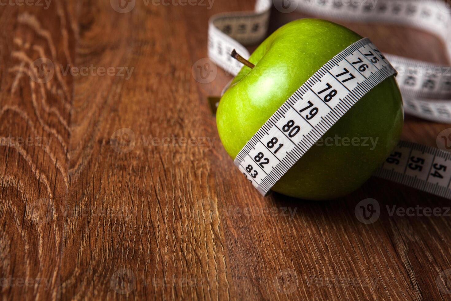 fresh green apple on a wooden table with measure photo