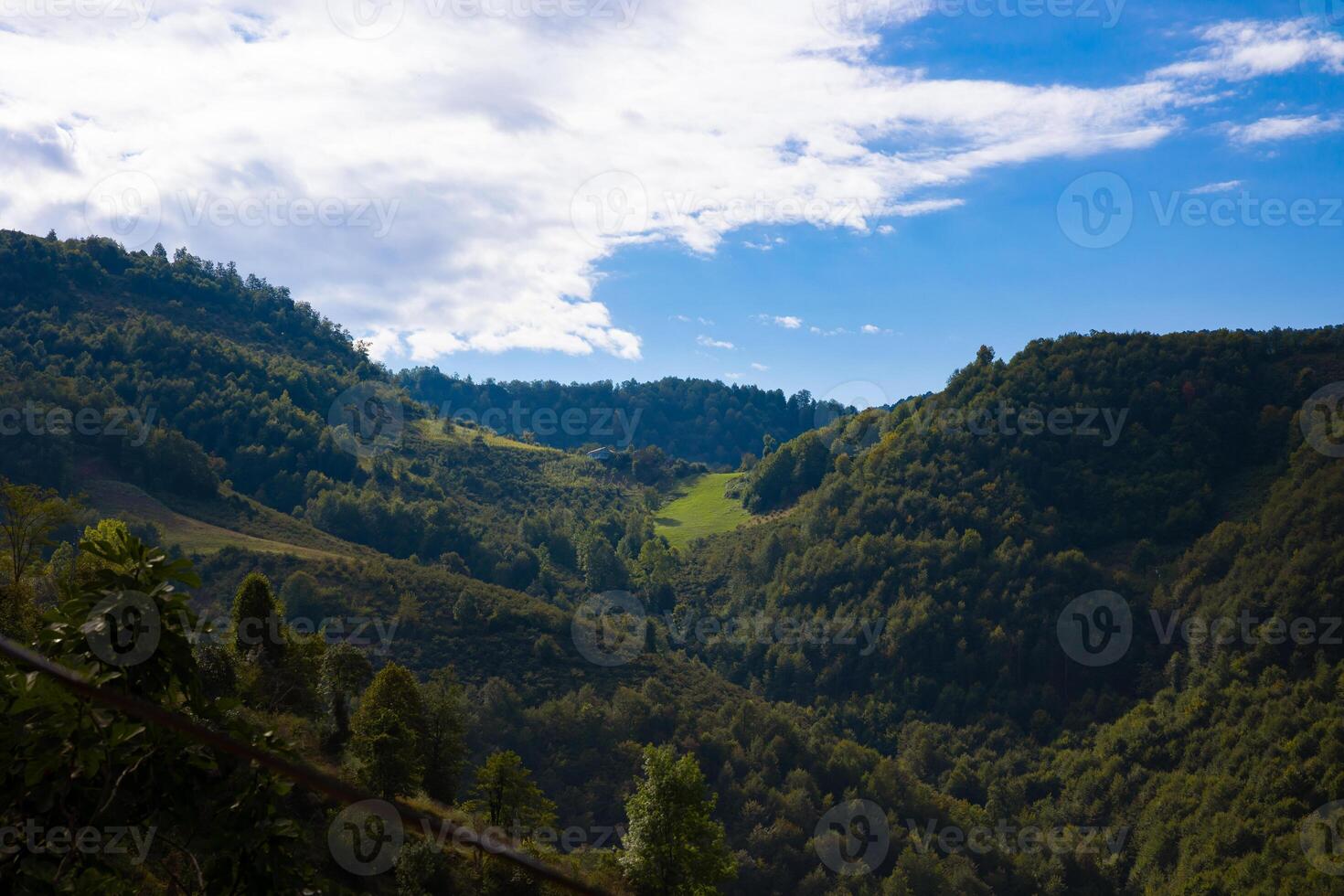 Forest covered mountains and partly cloudy sky. photo