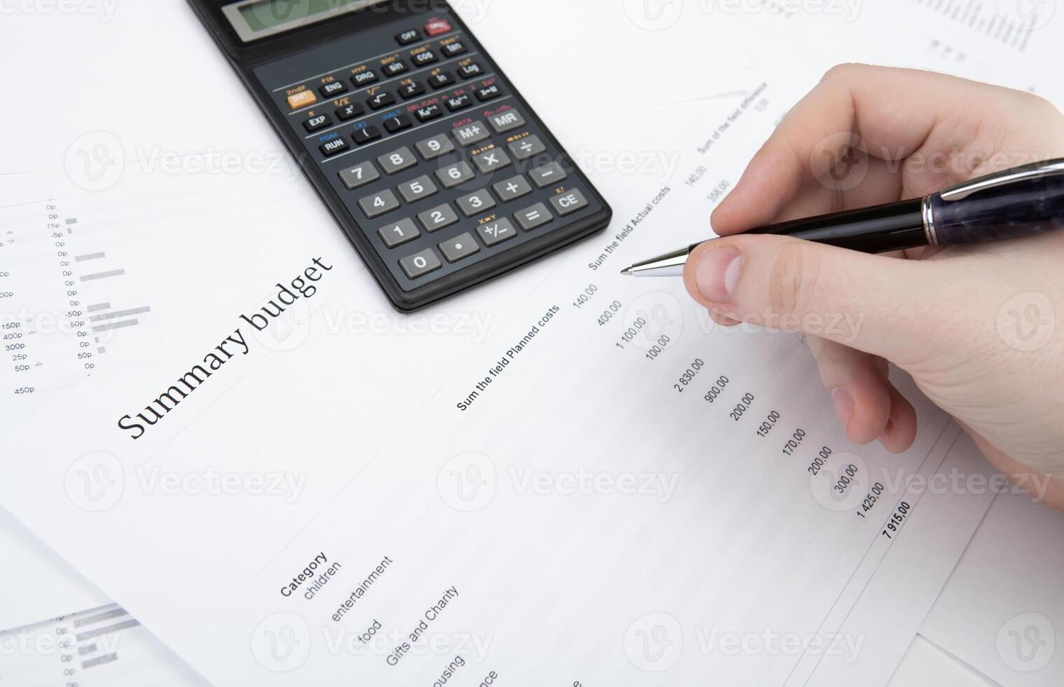 businessman holding a pen and counts the budget photo
