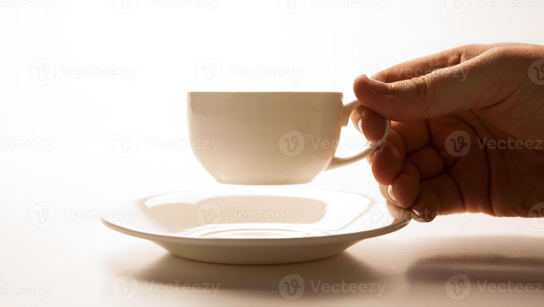 glass cup and saucer in hand closeup photo