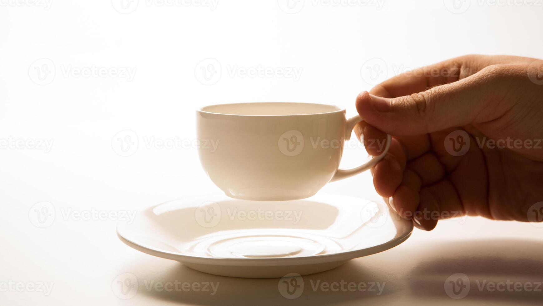 glass cup and saucer in hand closeup photo