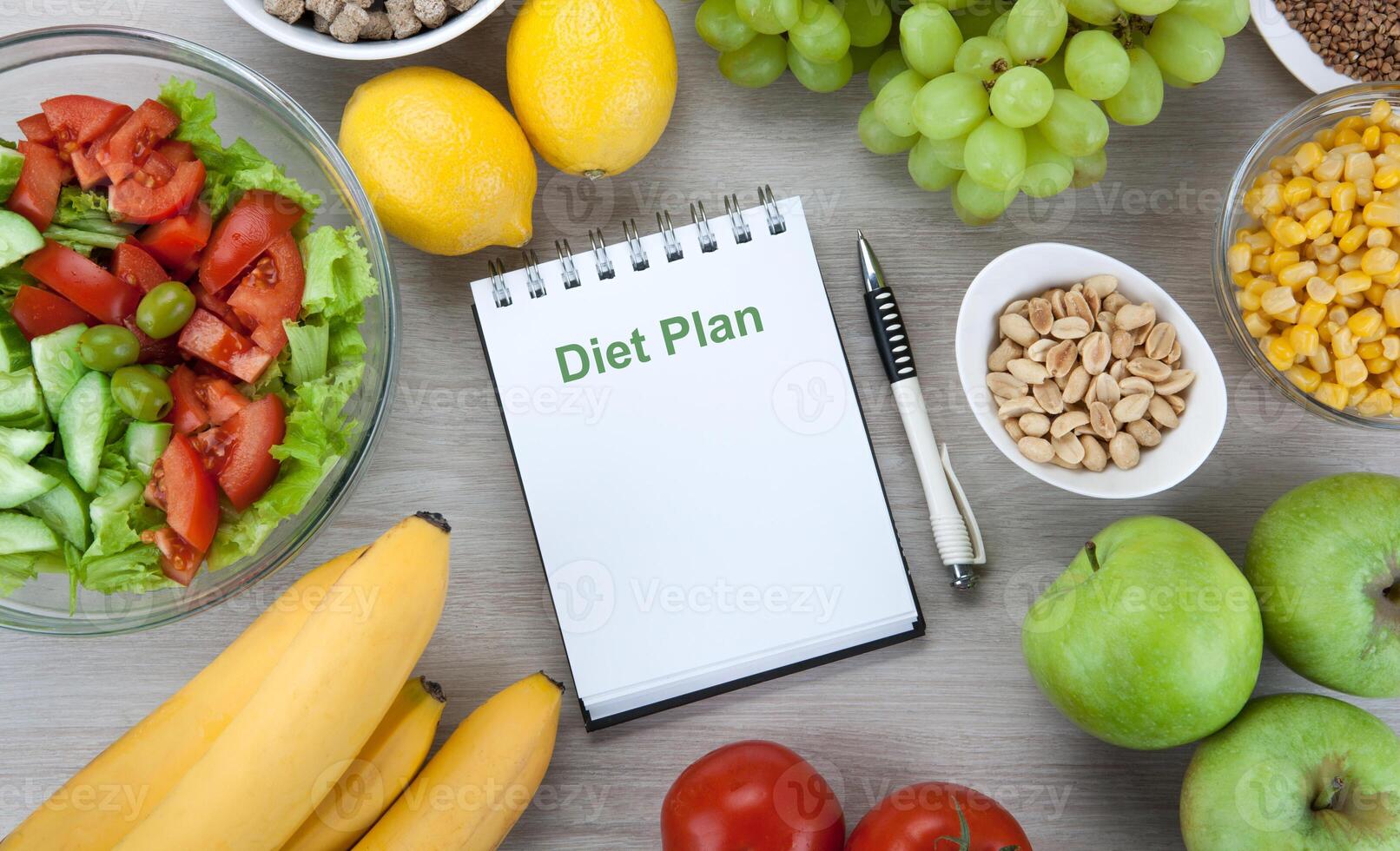 notebook with a diet plan with fresh vegetables and fruits on the table photo