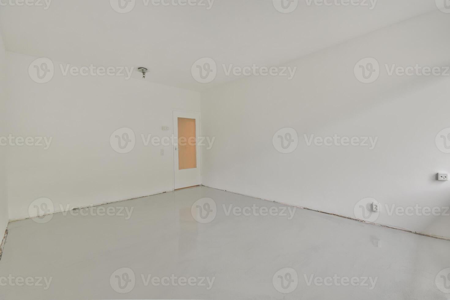 An empty room with white walls and a white floor photo