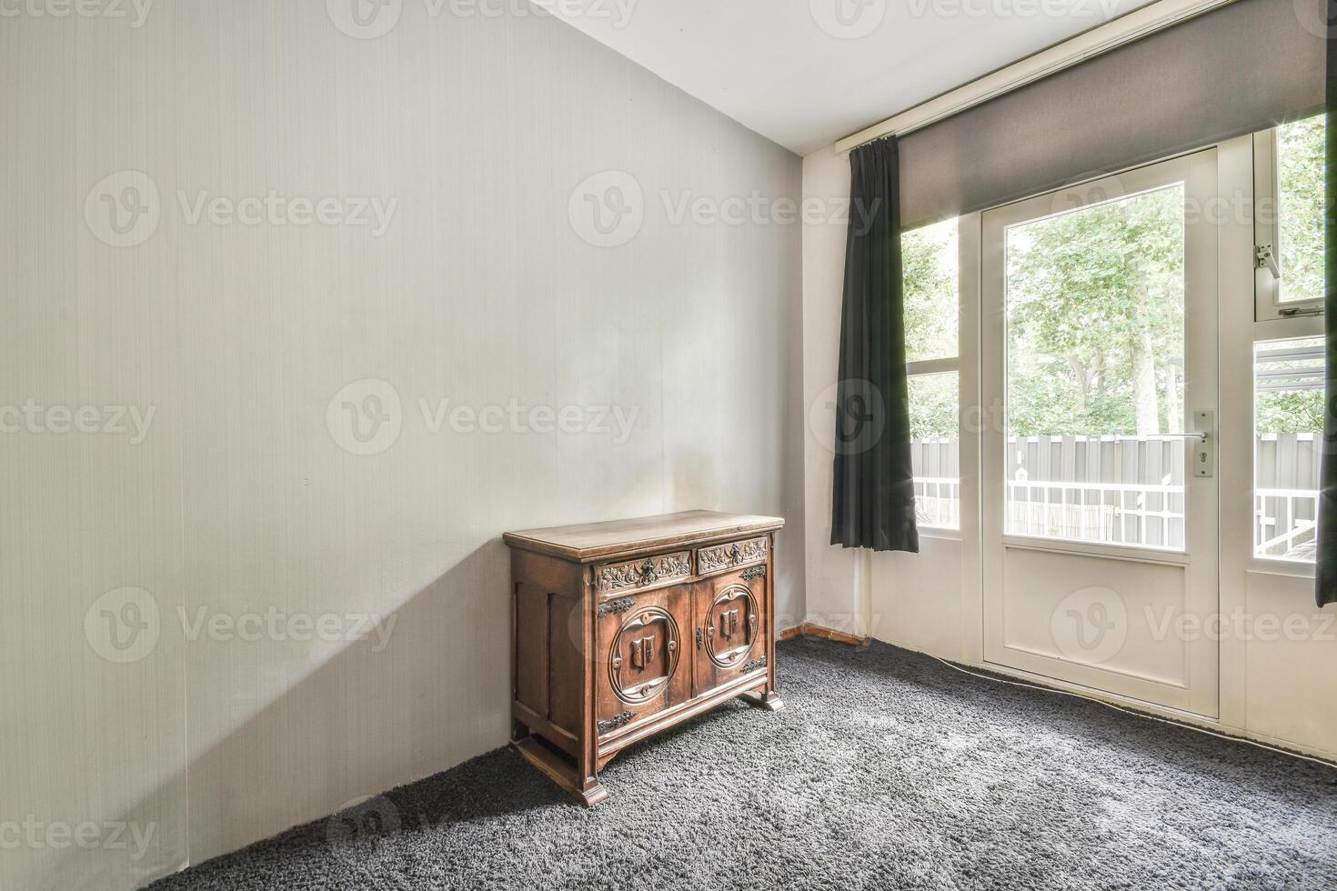 A room with a small cabinet and a window photo