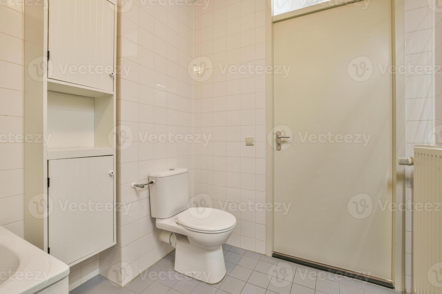 A bathroom with a toilet, sink and cabinet photo