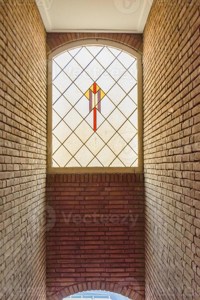 A stained glass window in a brick building photo