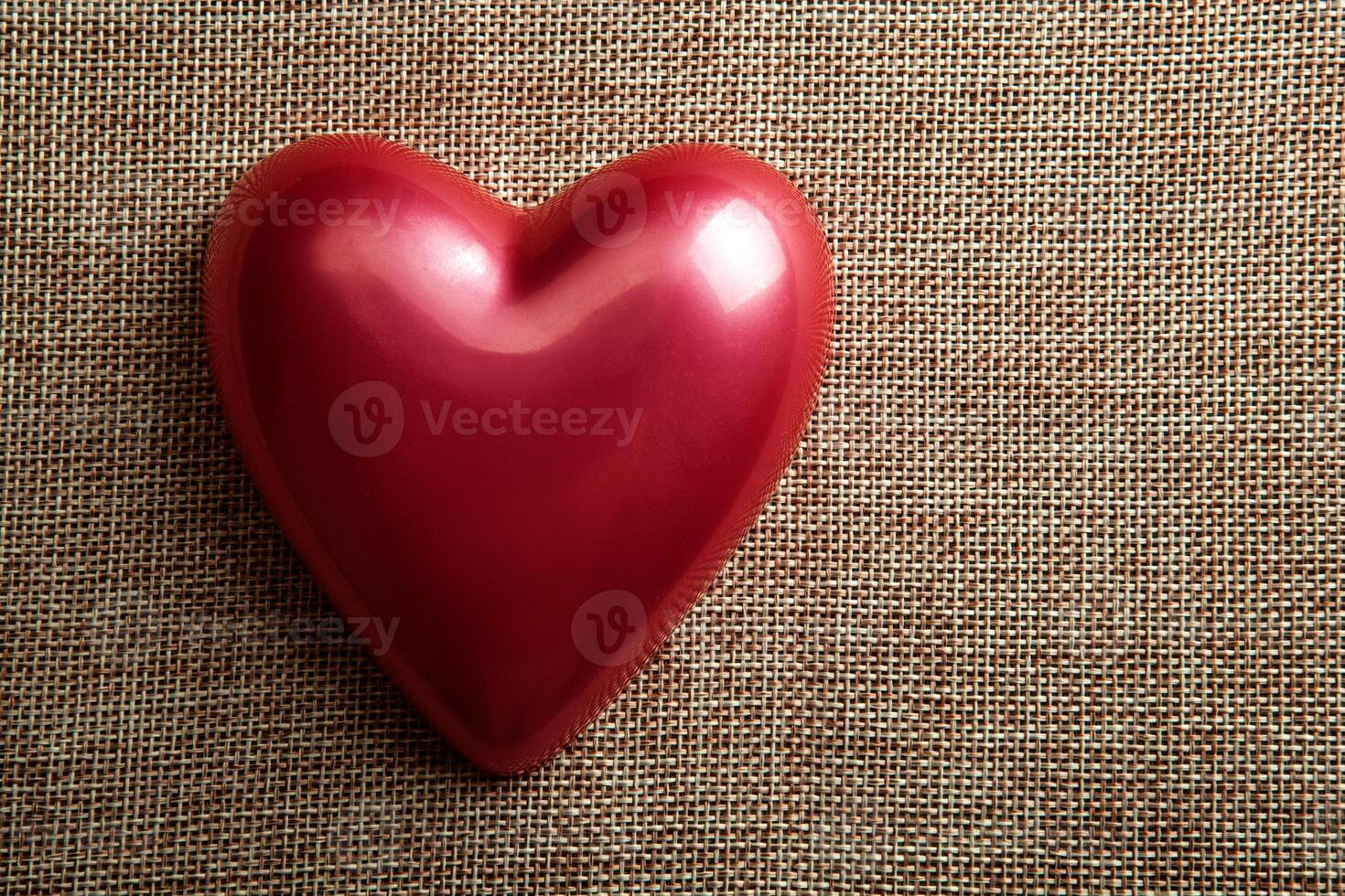 red glossy heart on linen top view photo