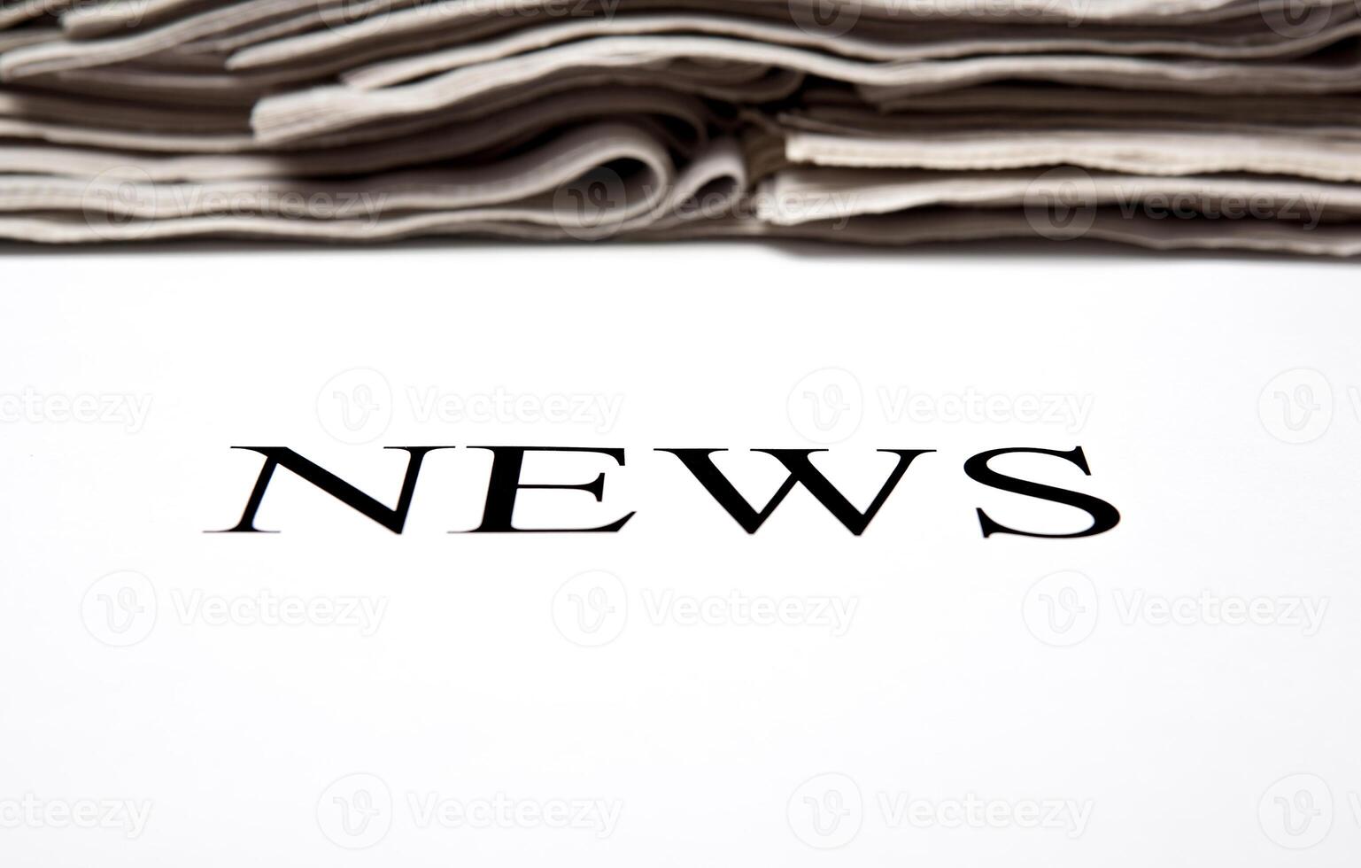 the word news on the background of a stack of newspapers photo