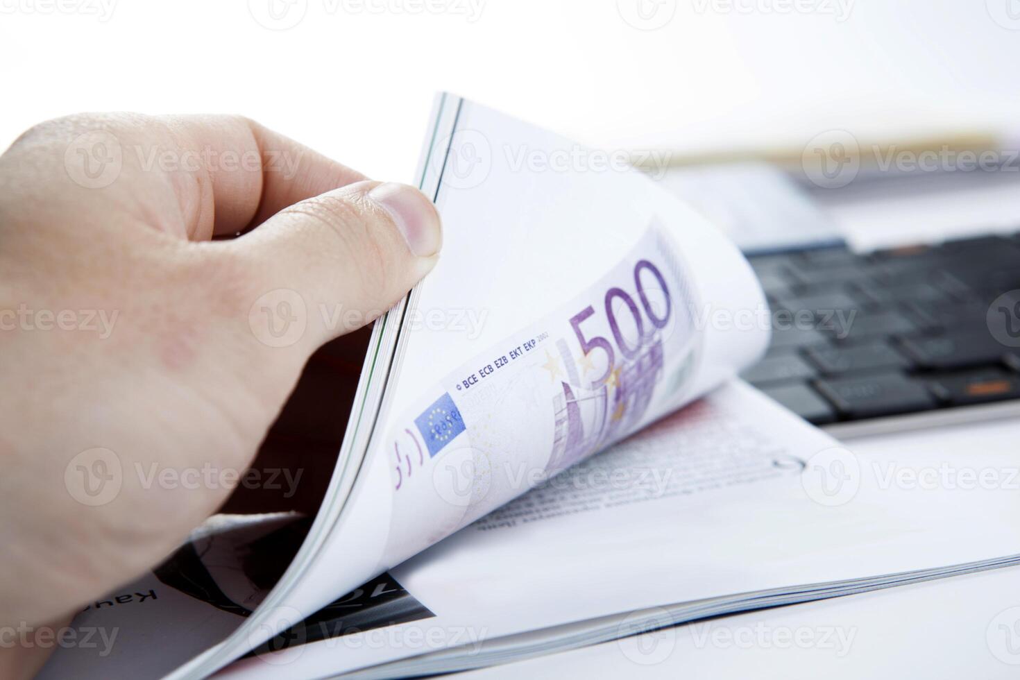 the hand through the pages of the magazine with currency note photo