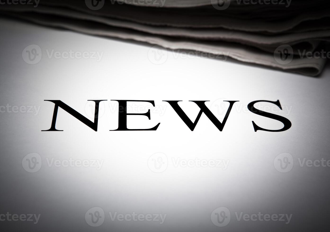 the word news on the background of a stack of newspapers photo