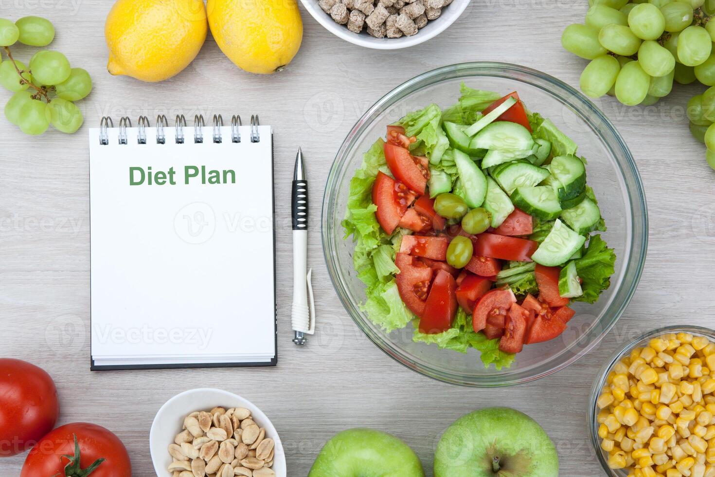 notebook with a diet plan with fresh vegetables and fruits on the table photo