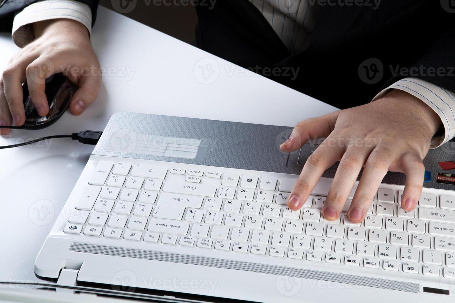 human hands on the notebook keyboard and mouse photo