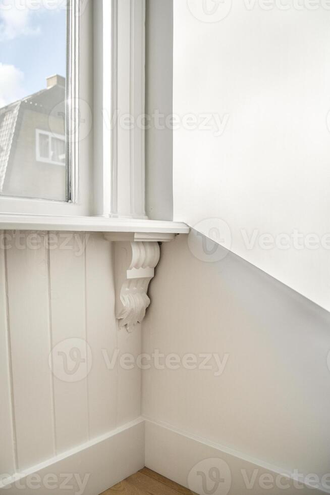 A corner of a room with a window and a shelf photo