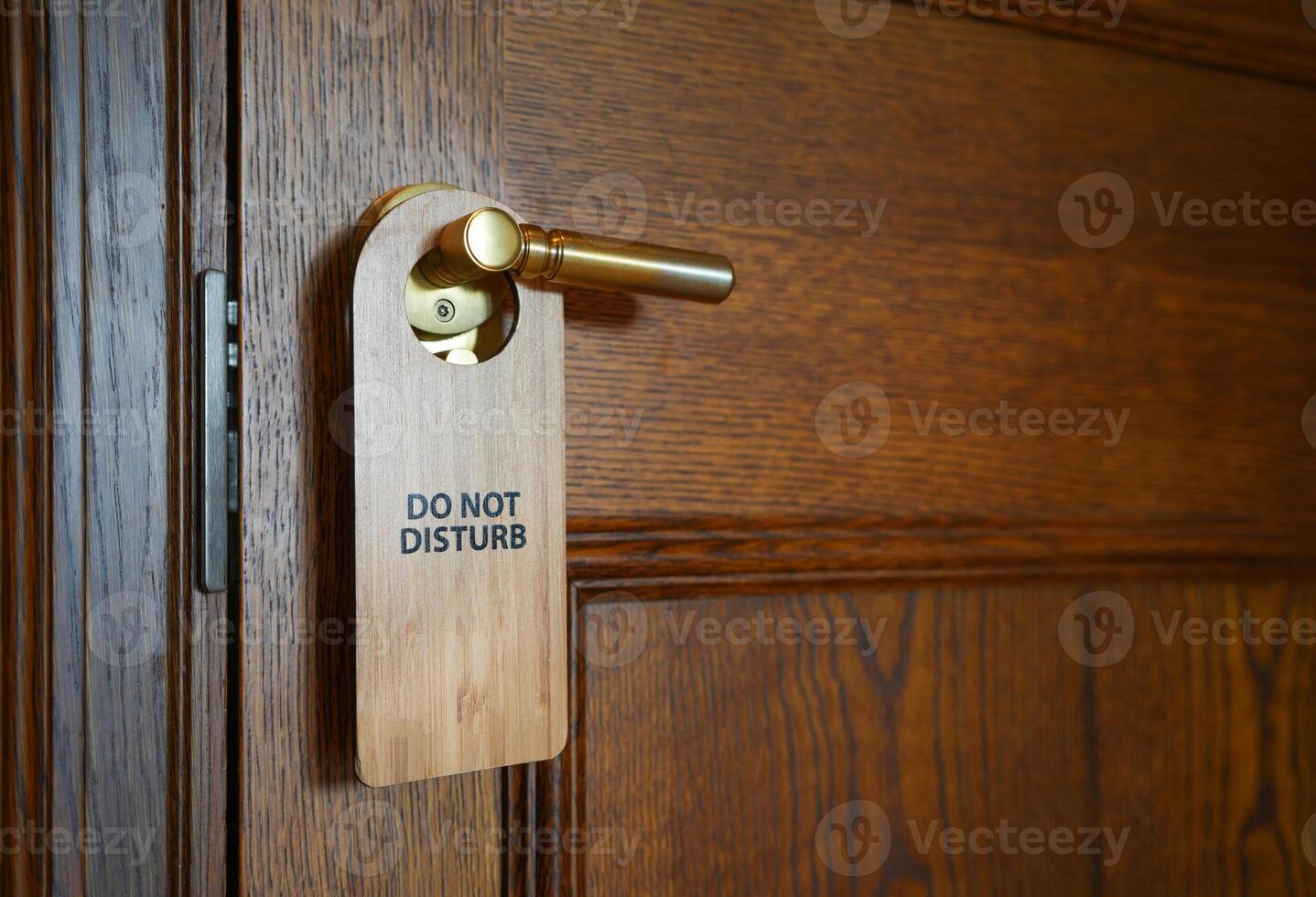 Please do not disturb sign hanging on the door handle in hotel room. photo