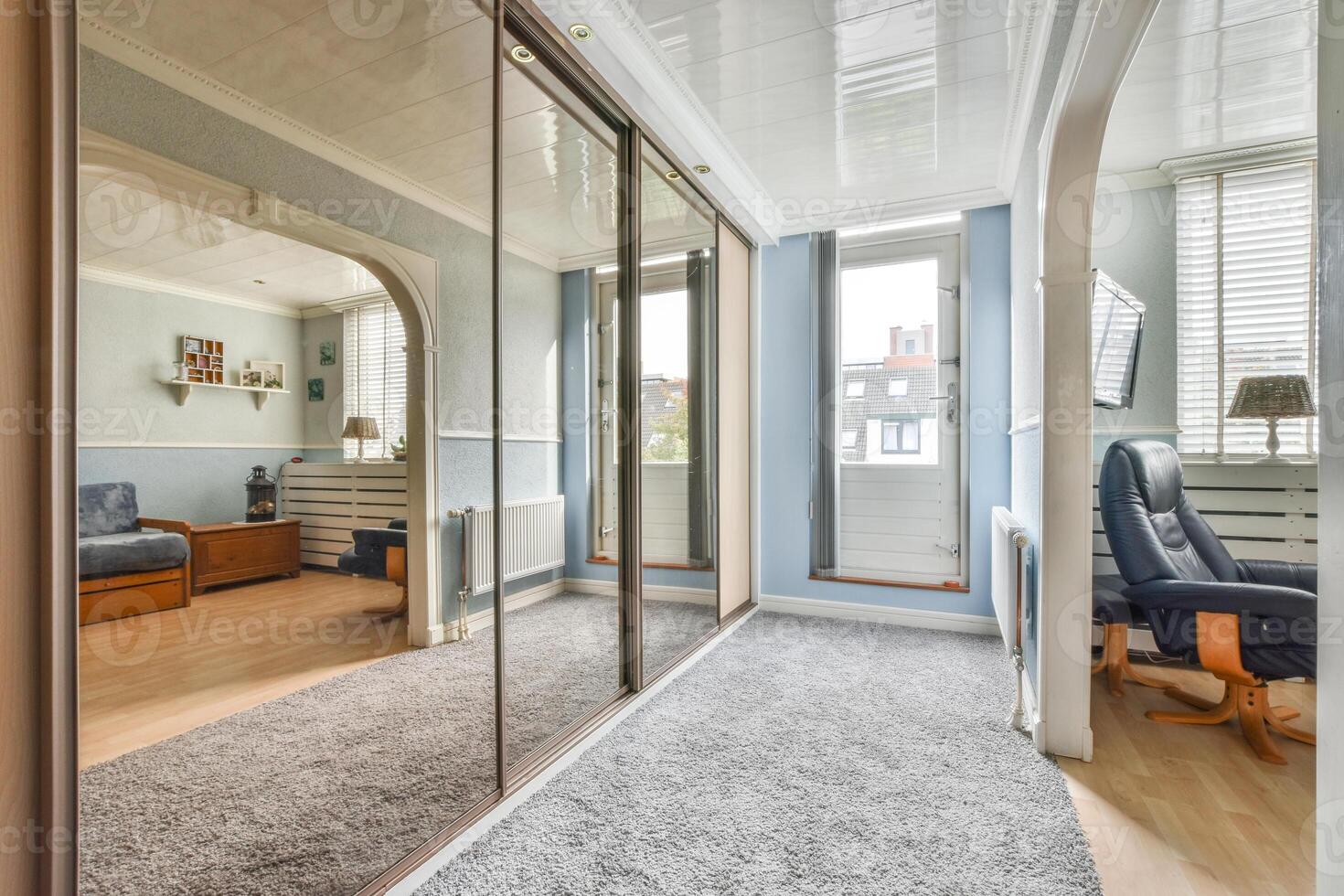 A bedroom with a mirror and a chair photo